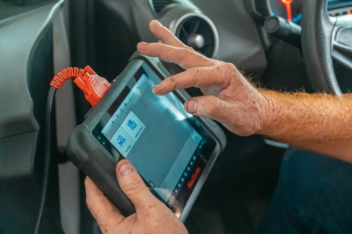 自動車内でのメカニカルの診断ツールを使用し、エンジンの問題を確認し、適切な保守を確保する作業。